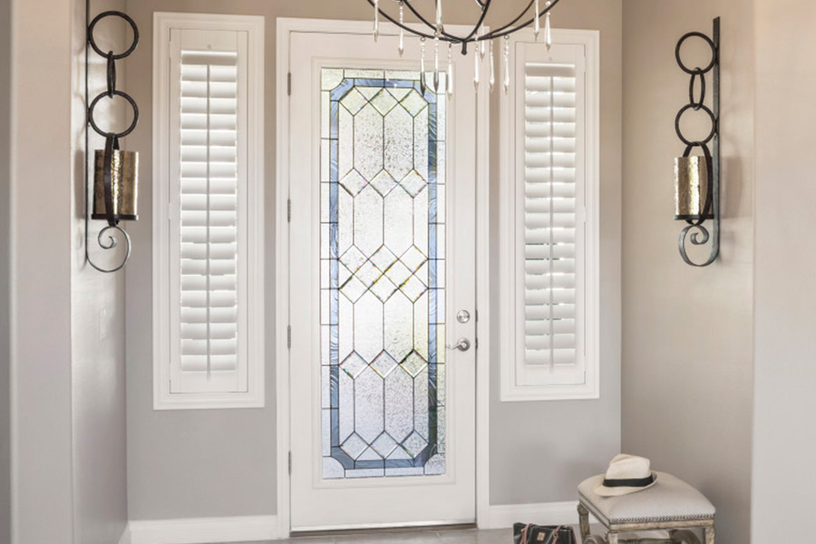 Sidelight windows with white polywood shutters in a foyer.