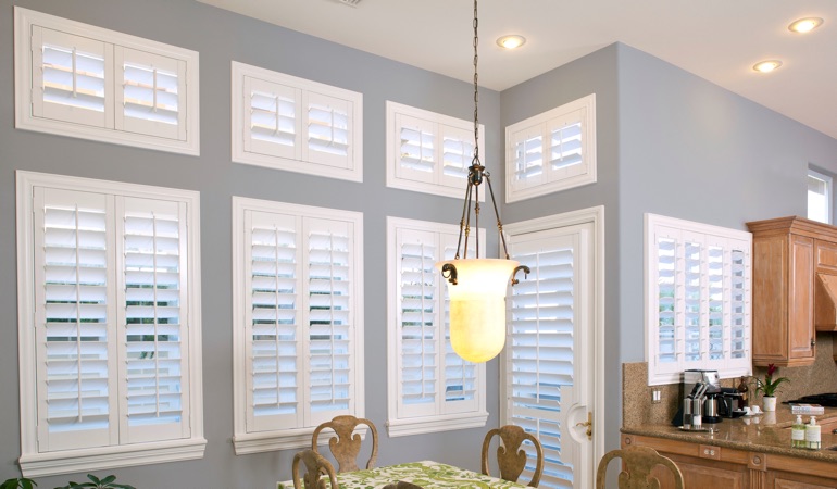 Interior Shutters can resolve both sun glare and energy efficiency problems. White plantation shutters in kitchen