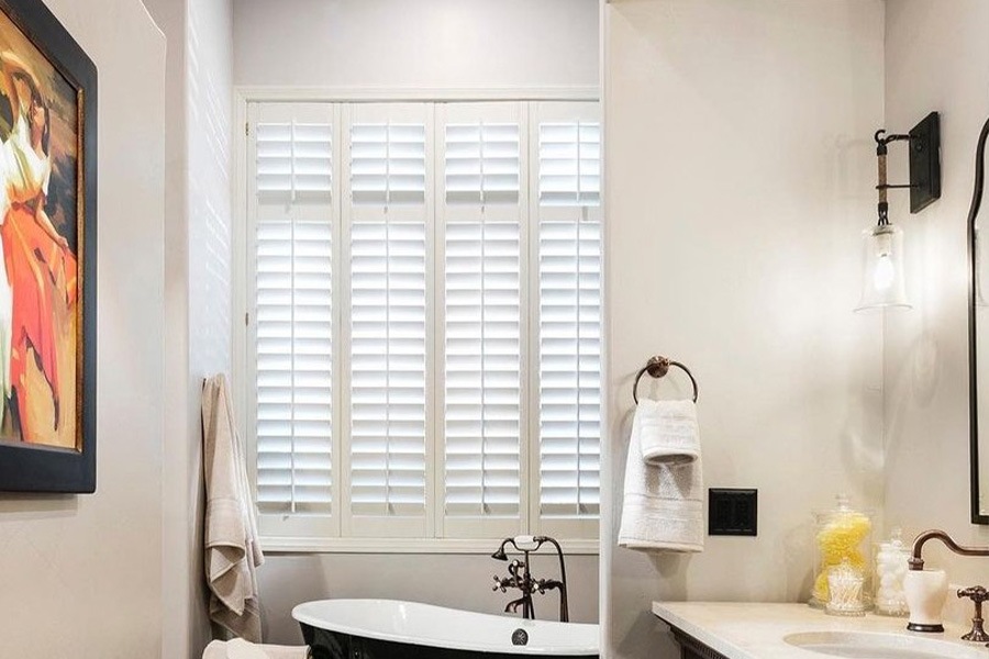 Custom-made interior windows are a perfect fit for your exterior awnings. Wide white Polywood shutters inside a bathroom.