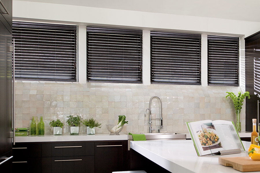 Choose custom Polywood faux wood blinds for your kitchen in Philadelphia. Special shaped faux wood blinds in several windows above a sink.