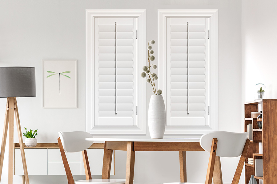 Sunburst's selection of stylish window treatments for designers in Philadelphia makes it easy to find the perfect ones for every design job.  White Polywood shutters on two windows in a modern Scandinavian-style room