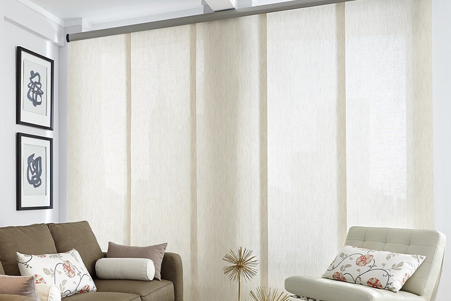 Find window treatments to complete any interior design among our extensive selection at Sunburst Shutters Philadelphia.  Long off-white window shades on a tall window in a modern living room