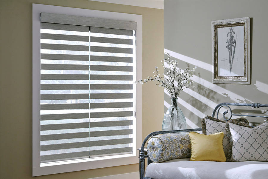 Find Versatile and stylish window blinds for Philadelphia homes at Sunburst. Gray blinds on a large window next to a couch.