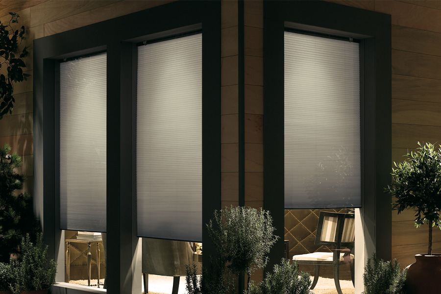 Cellular shades are modern and stylish window treatments for your home in Philadelphia. Dark gray cellular shades displayed from the exterior of a home.